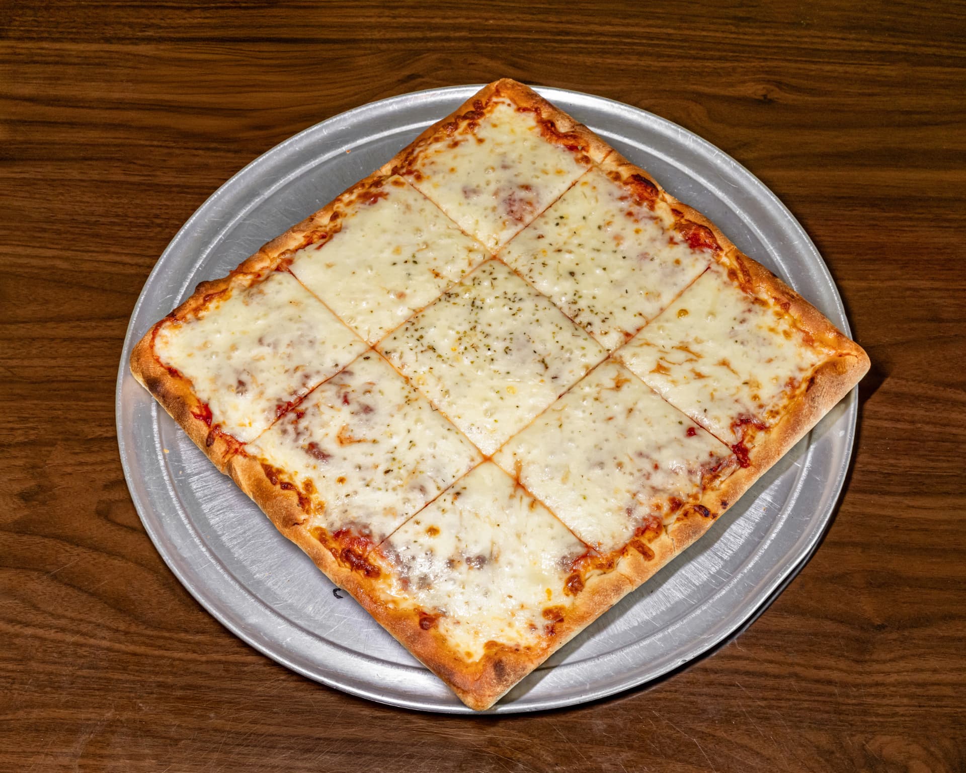 Square cut Sicilian pan pizza on a metal tray